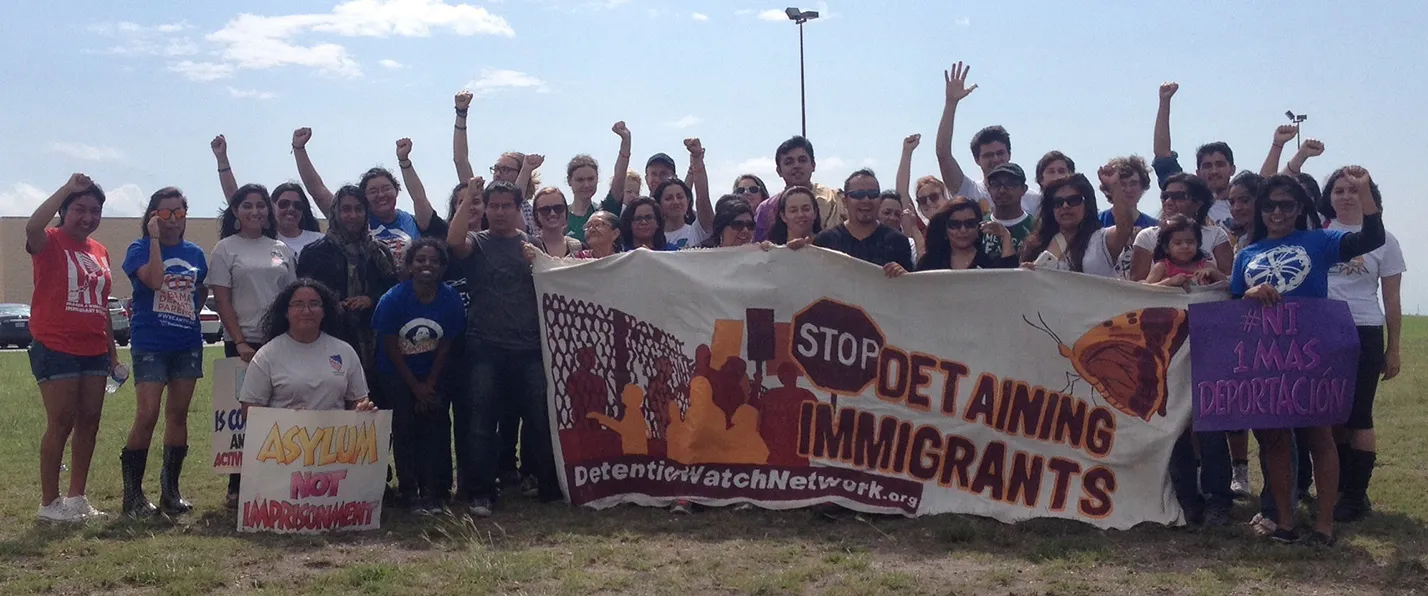 Rally participants with “Stop Detaining Immigrants” banner